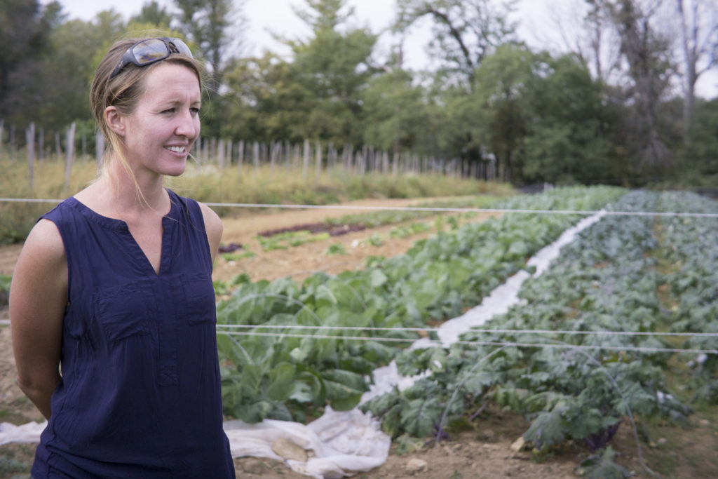 Farmer Tonya Taylor beside her specialty crops (leafy greens).